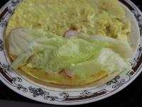 Omeletu vyklopíme na tortilu. Polovicu omelety...